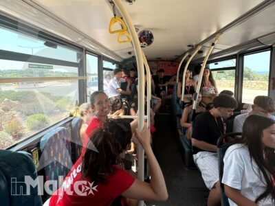 Studenti seduti e in piedi su un autobus osservano il paesaggio maltese durante uno spostamento di gruppo.