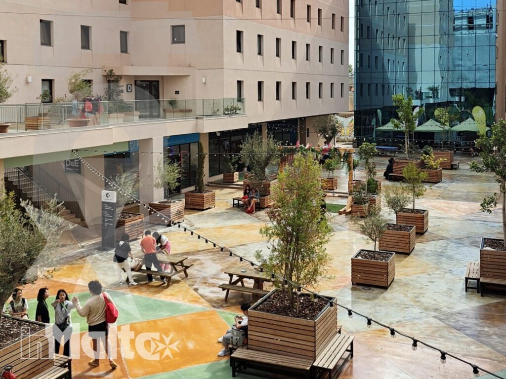 Spazi esterni del campus per la vita degli studenti Edifici moderni, facciate vetrate, piante e pavimentazione colorata definiscono il cortile dove gli studenti trascorrono il tempo libero.
