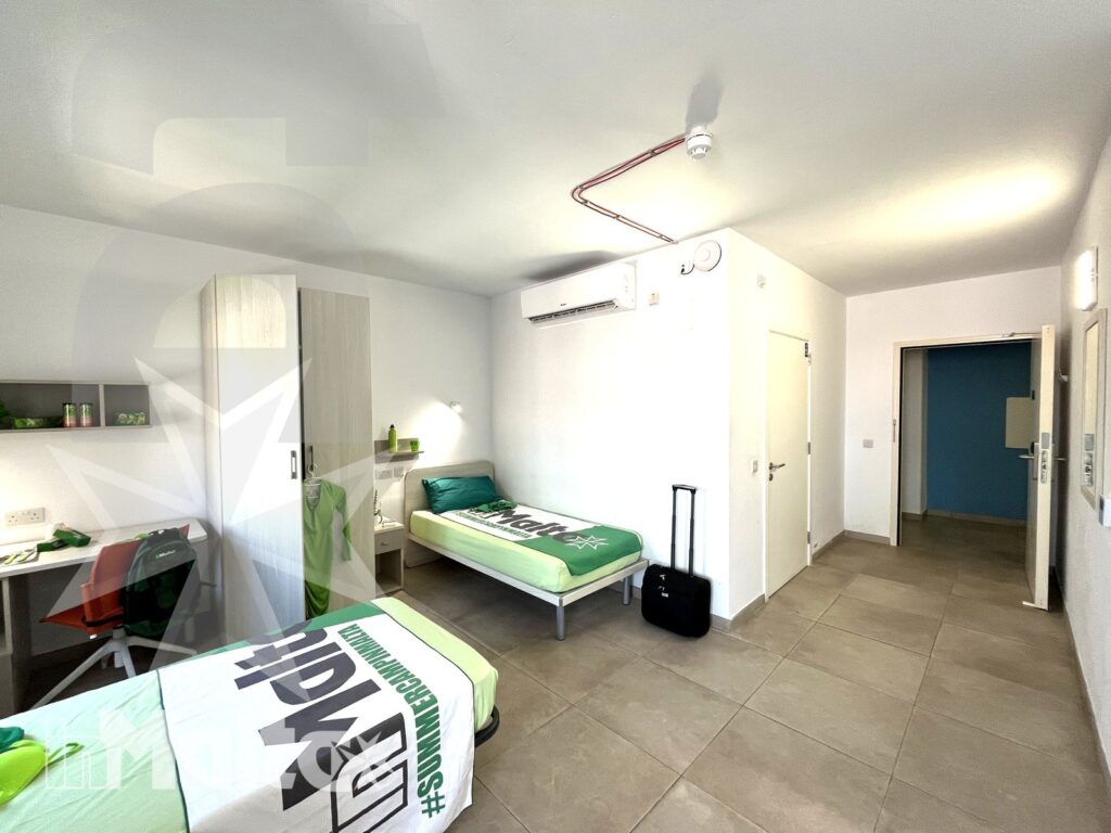 Vista interna della camera tripla Campus inMalta con tre letti singoli
