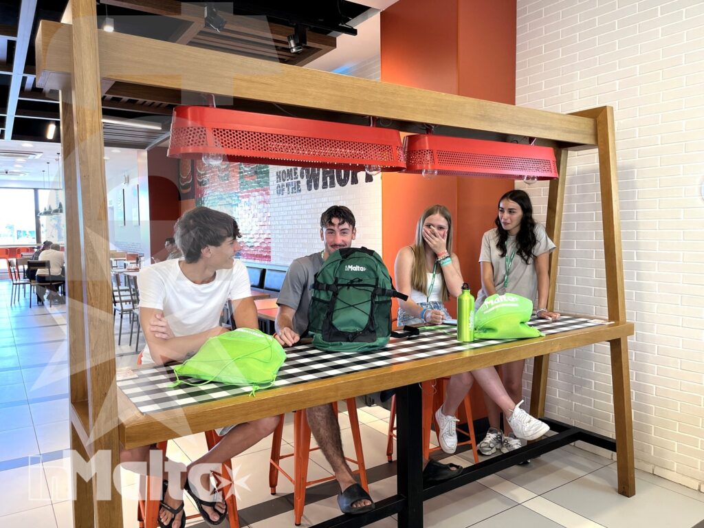 Gruppo di studenti riunito in un ambiente moderno e conviviale, durante una pausa del soggiorno linguistico.