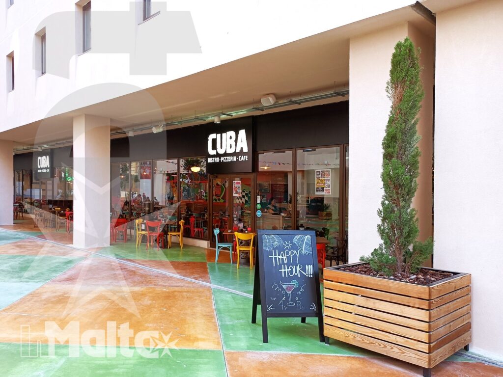 Ingresso del ristorante Cuba con tavoli esterni colorati, insegna, lavagna promozionale e fioriera sotto il porticato.