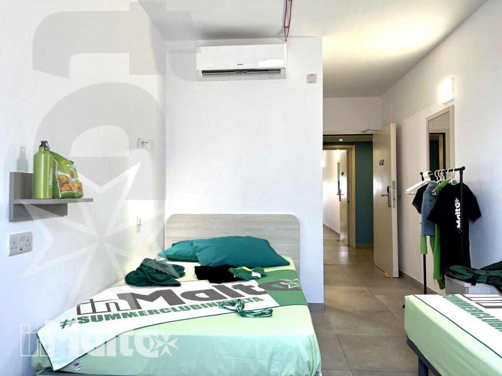 Camera singola del Campus inMalta con letto, armadio e ingresso