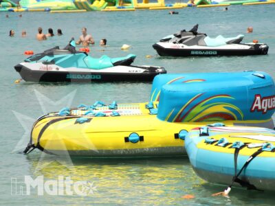 Sofà Ride e altri gonfiabili colorati sulla costa pronti per una giornata di sport acquatici
