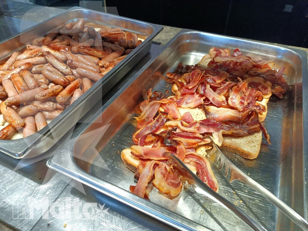Salini Resort - Bacon e preparazioni calde al buffet Vassoi con bacon, salsicce e altre preparazioni calde del buffet