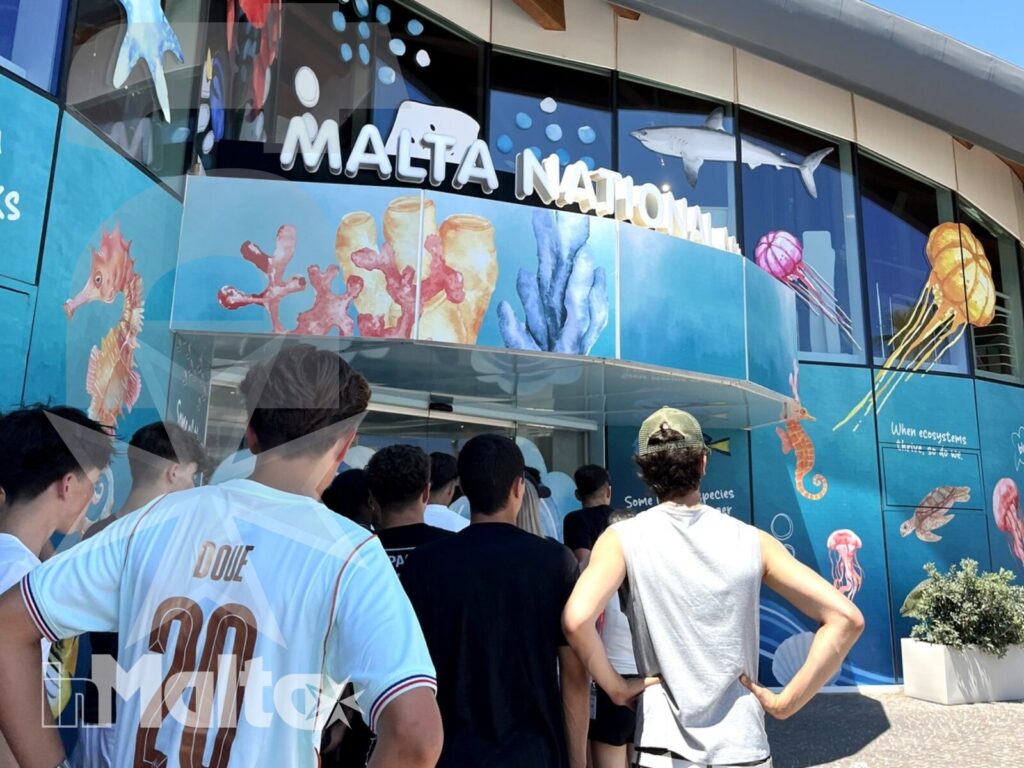 Studenti in attesa davanti al Malta National Aquarium Studenti attendono davanti all'ingresso del Malta National Aquarium, decorato con un grande murale dedicato alla vita marina.