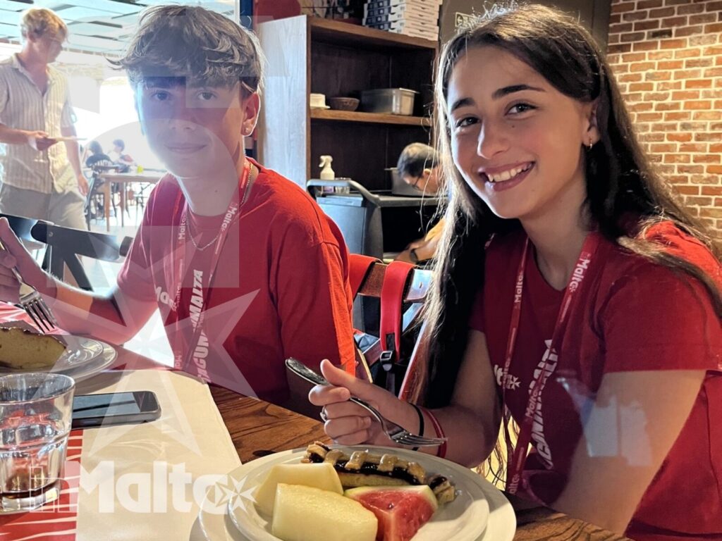 Salini Resort - Studentessa inMalta sorride durante la cena Studentessa inMalta sorride a tavola durante la cena al Salini Resort