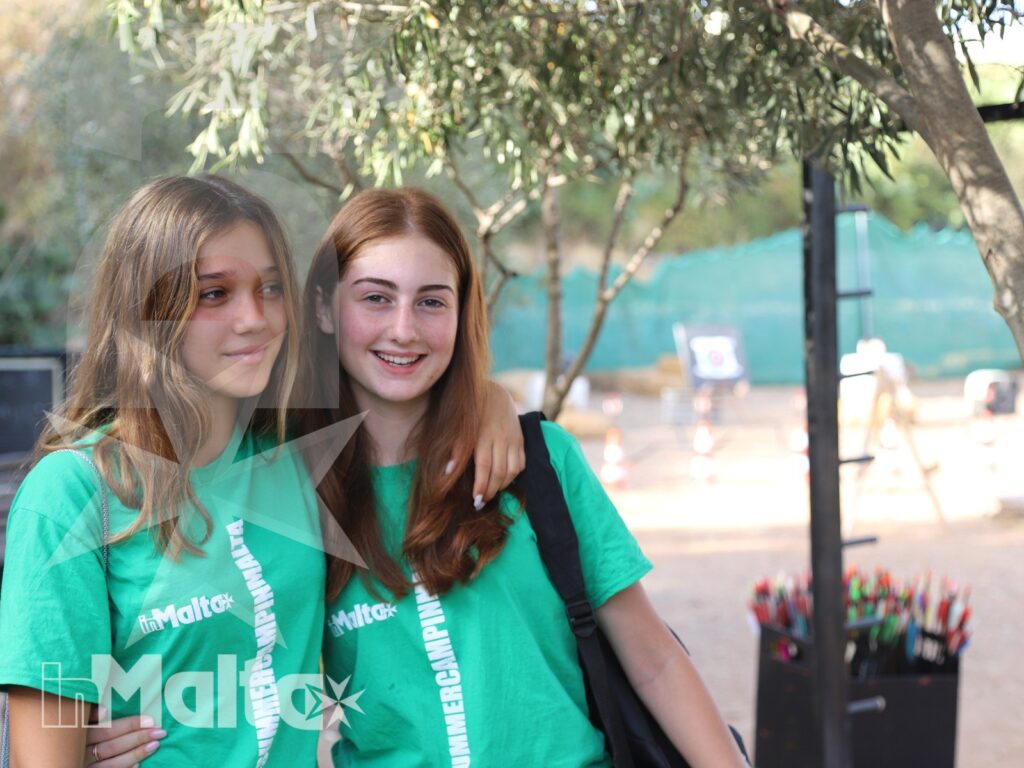 Due studentesse sorridono vicine con le magliette verdi del gruppo durante il soggiorno studio a Malta.