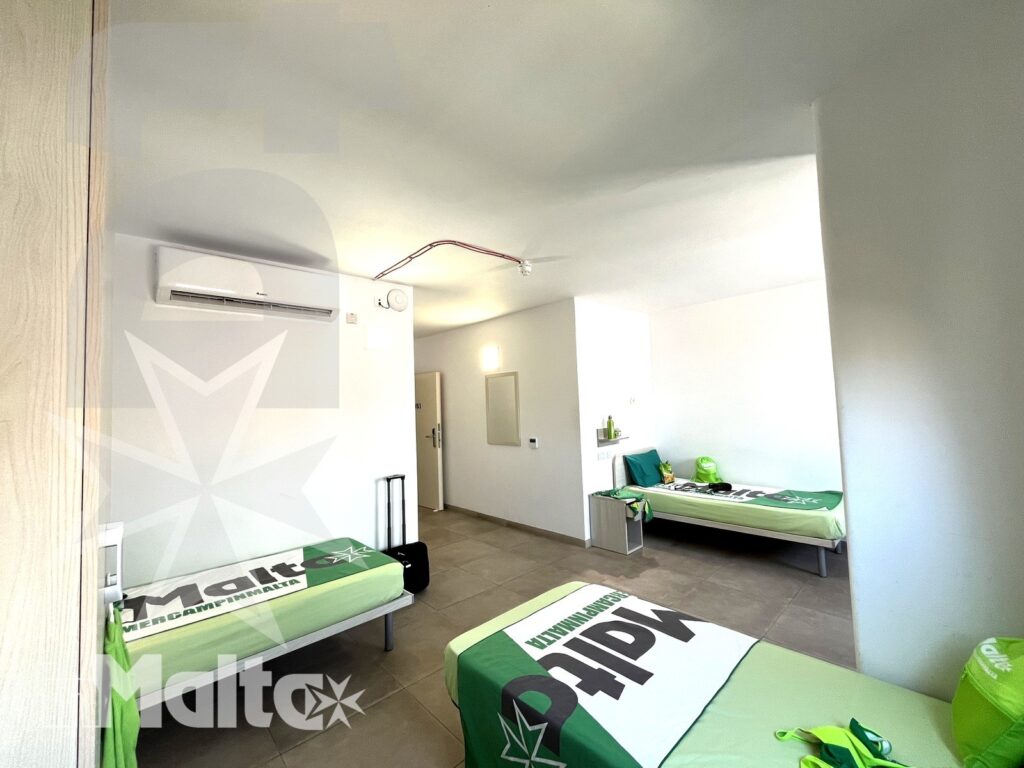 Camera tripla del Campus inMalta con letti, armadi e zona studio