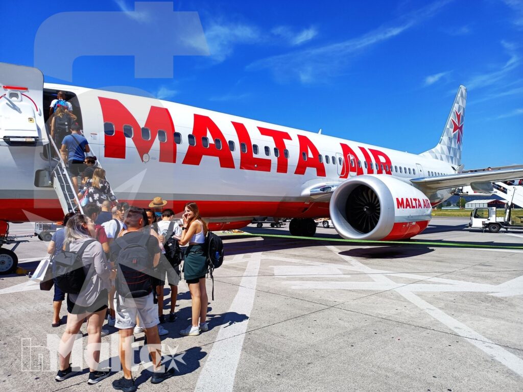 Studenti salgono la scaletta di un aereo Air Malta sulla pista, pronti a partire per un soggiorno studio.