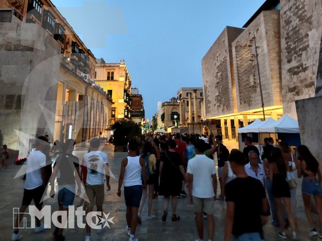 Un gruppo di studenti cammina nel centro storico illuminato, esplorando a piedi l'architettura urbana durante un soggiorno studio.