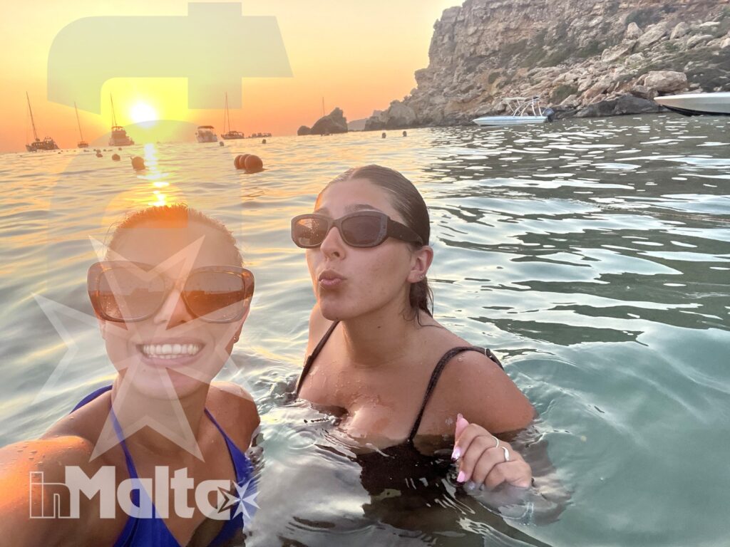 Studentesse inMalta in acqua durante la Night Swim Experience al tramonto