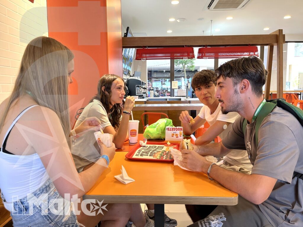 Gruppo di studenti internazionali riuniti al ristorante, in un momento conviviale della vita sociale inMalta.