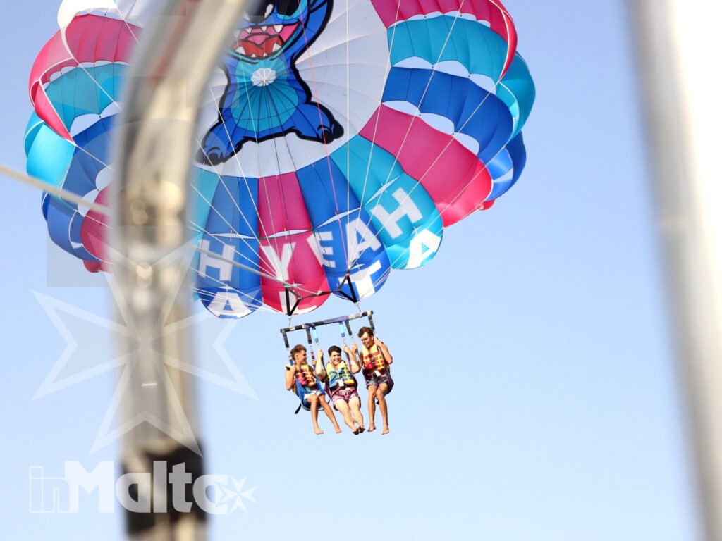 Volo in parasailing sul mare di Malta Ragazzi sospesi con il paracadute durante il parasailing a Malta