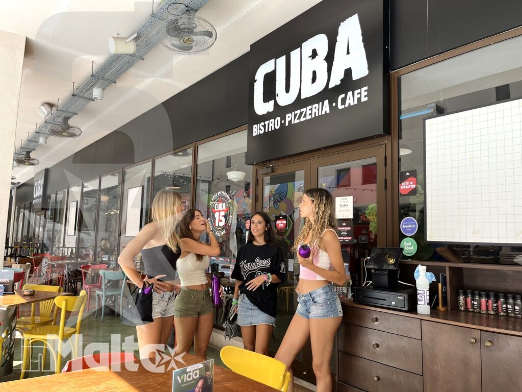 Studentesse inMalta davanti al ristorante durante il viaggio studio Gruppo di studentesse posa davanti a un ristorante con insegna leggibile, in un'atmosfera vivace del viaggio studio inMalta.