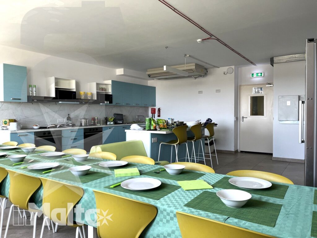 Cucina comune e tavolo apparecchiato - Campus inMalta Cucina comune del Campus inMalta con tavolo apparecchiato e zona cottura