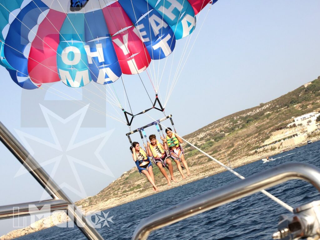 Ragazzi in parasailing lungo la costa di Malta Ragazzi in volo con il parasailing lungo la costa di Malta