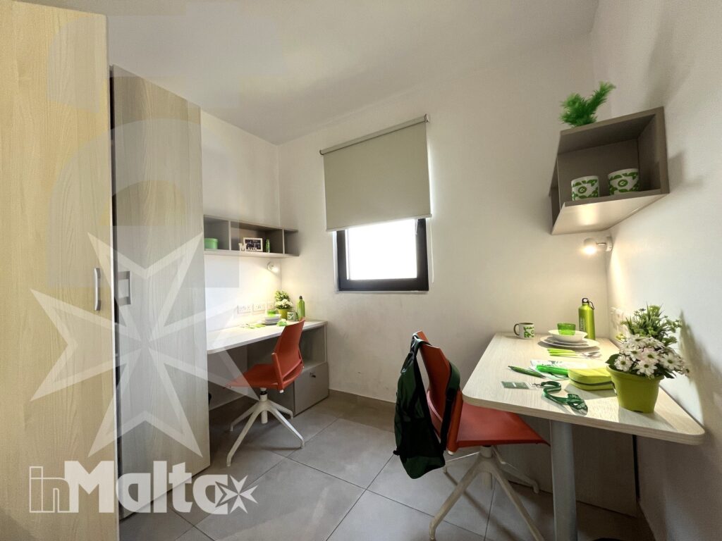 Zona studio della camera doppia Campus inMalta con scrivania e sedia