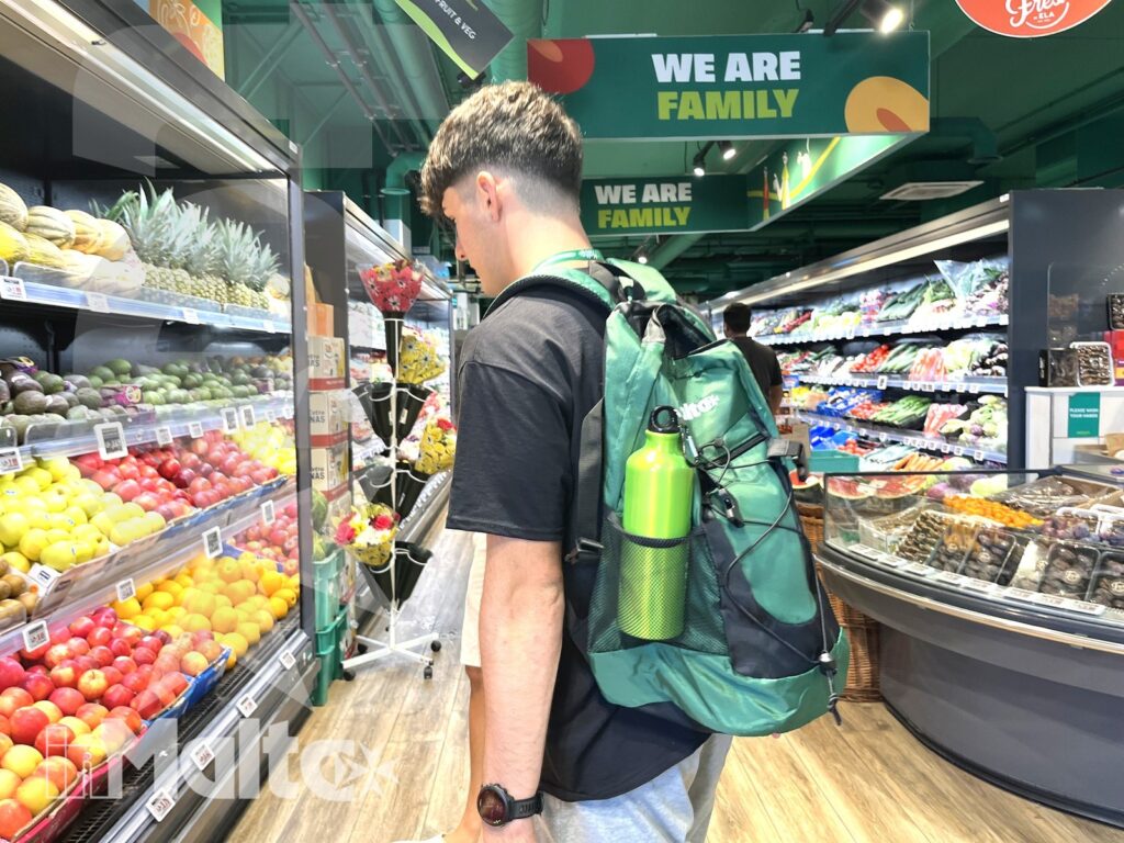 Spesa da Welbee's nel Campus - inMalta Ragazzo mentre sceglie frutta e verdura al supermercato Welbee's del Campus inMalta