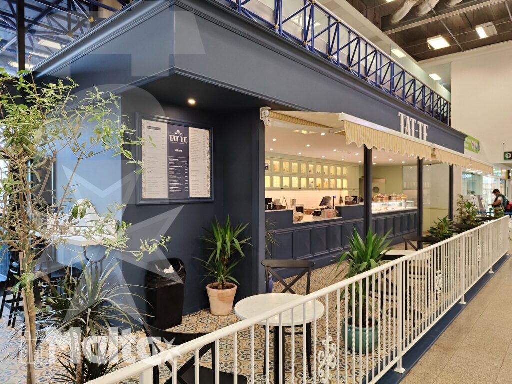 Ristorante e caffetteria per i partecipanti in arrivo a Malta Caffetteria o ristorante luminoso con insegna, bancone, menu esposto, piante decorative e area esterna curata.