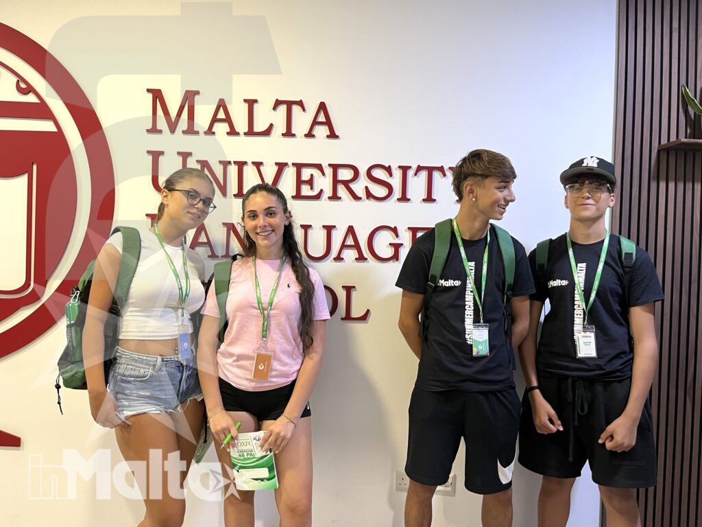 Partecipanti inMalta davanti alla scuola di lingue Quattro studenti con badge e zaini posano davanti alla Malta University Language School, durante una visita organizzata inMalta.