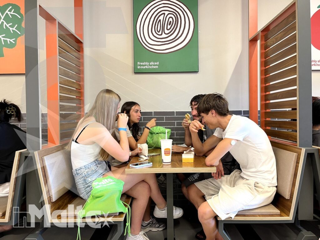 Gruppo di studenti rilassato durante un pasto, in una scena di socialità e condivisione tipica delle vacanze studio.