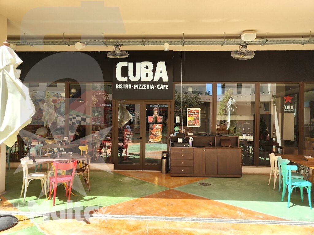 Facciata colorata del Cuba Bistro-Pizzeria-Café con tavoli e sedie sulla terrazza, servizio di ristorazione del Campus Hub inMalta.