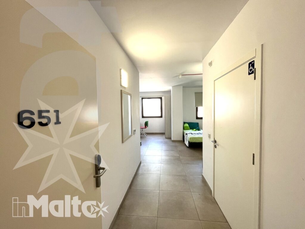 Ingresso della camera tripla del Campus inMalta con corridoio e armadi