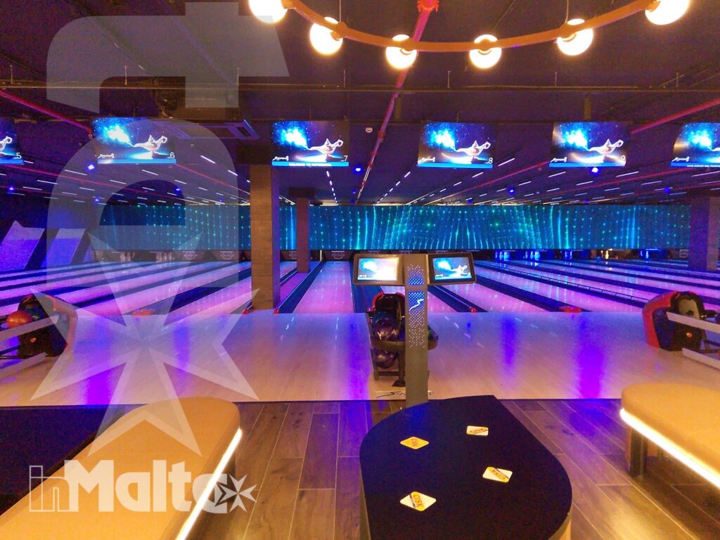 Piste illuminate del centro bowling per attività ricreative Piste da bowling vuote con monitor e illuminazione al neon colorata, in una moderna struttura ricreativa al coperto.